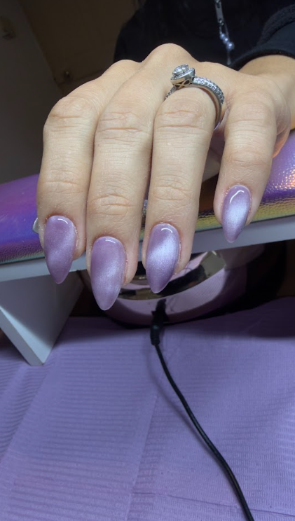 Uñas terminadas en tono lila con brillo
